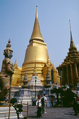 Bangkok - Wat Phra Kaeo, links ein Yak-Dämone, Mitte: der vergoldete Phra Sri Ratana Chedi (mit Reliquien Buddhas), rechts die königliche Bibliothek (Phra Mondhop)