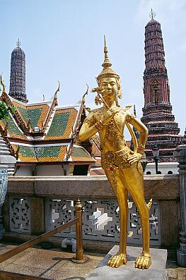 Bangkok - Wat Phra Kaeo, ein goldener "Kinara" (mythisches Fabelwesen), dahinter Prangs an der östlichen Begrenzung des Wat