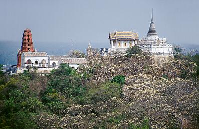 Petchaburi - Blick vom "Bergschloss" auf den Nachbarhügel mit einem Tempel, einem weißen Chedi und einer roten Pagode